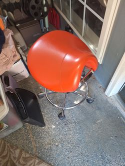 Rolling salon stool/saddle stool in Volunteer orange