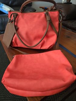 The LG Black Rivet Tote Bag is a stylish and versatile accessory for women, made from vegan leather with a solid coral exterior color and brown double