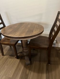 Round Wood Pedestal Dining Table and Two wood chairs