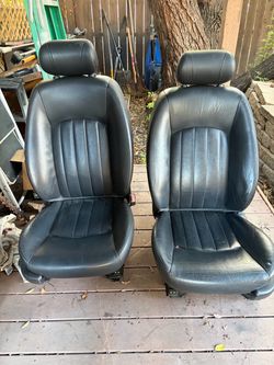 Two black leather bucket seats