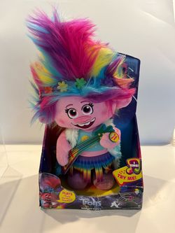 DreamWorks Trolls World Tour Dancing Poppy feature plush by Just Play, featuring vibrant hair and a guitar.This doll sings the song "Trolls Just Wanna