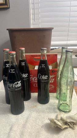 Old return for refund money back bottle 16 ounce Coke three with red caps that are all full three with silver caps two of them empty