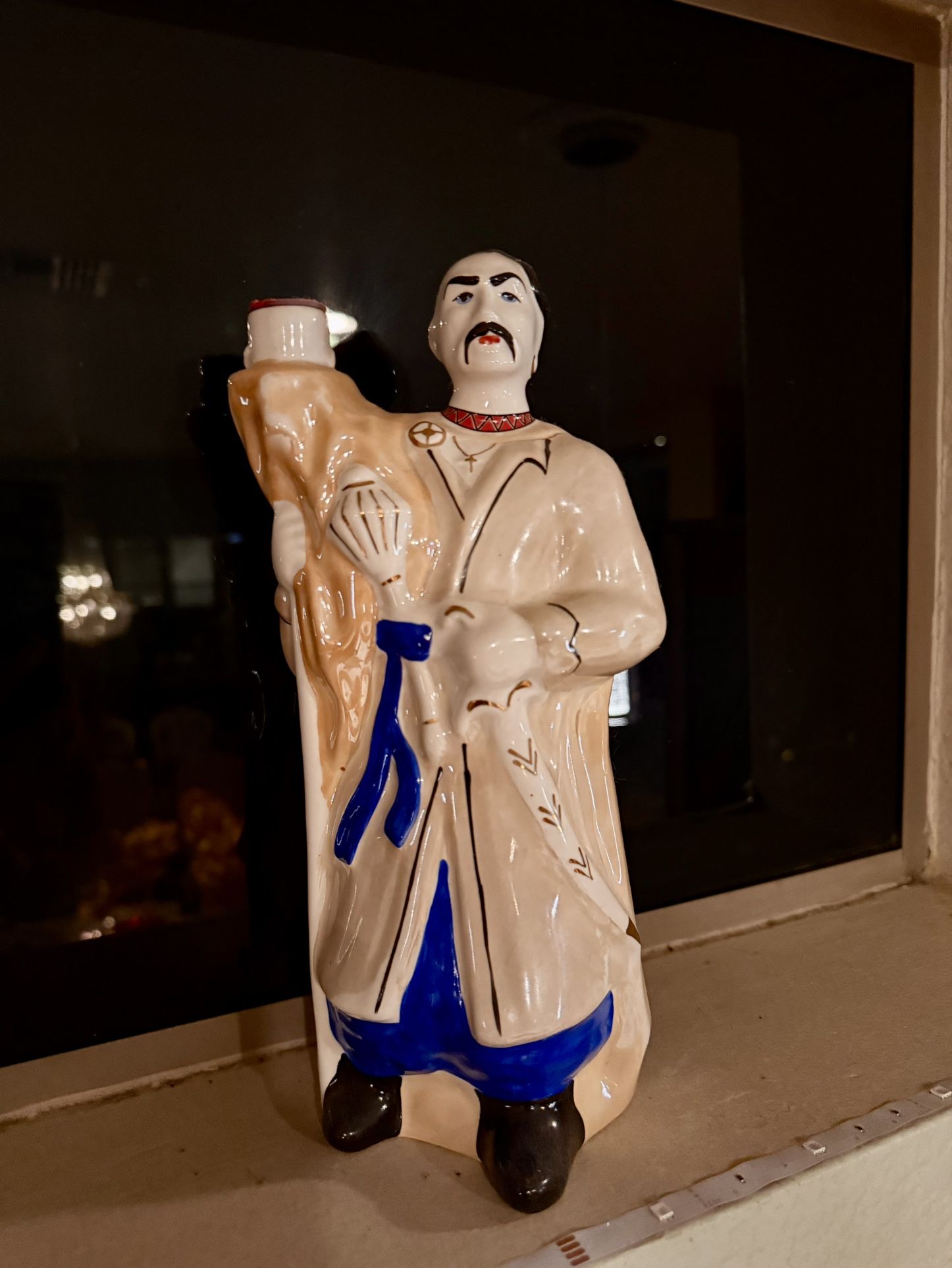 The figurine is a vintage Ukrainian Cossack porcelain bottle,