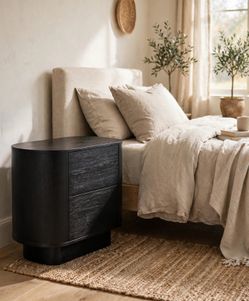 New Four Hands Paden Nightstand in Aged Black Acacia – 32″ Oval Nightstand – Delivery Available