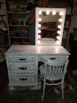Vanity with a lighted mirror and chair