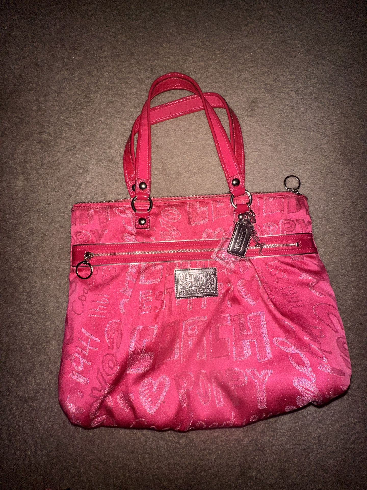 a Coach Poppy Hobo Tote bag, hot pink with silver hardware and all-over logo and heart print