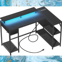 New Reversible L-Shaped Gaming Desk with LED Lighting, Monitor Stand, Shelves, and Integrated Power Station. New, Unassembled in Box
