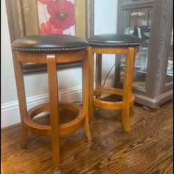Gorgeous wooden swivel bar stool with nailhead trim upholstered Faux  leather seating. 24-inch seat height in Cherry finish