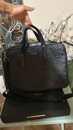 Coach Graham Slim Brief featuring an embossed signature leather design.