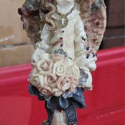 angel figurine holding rose bouquet 