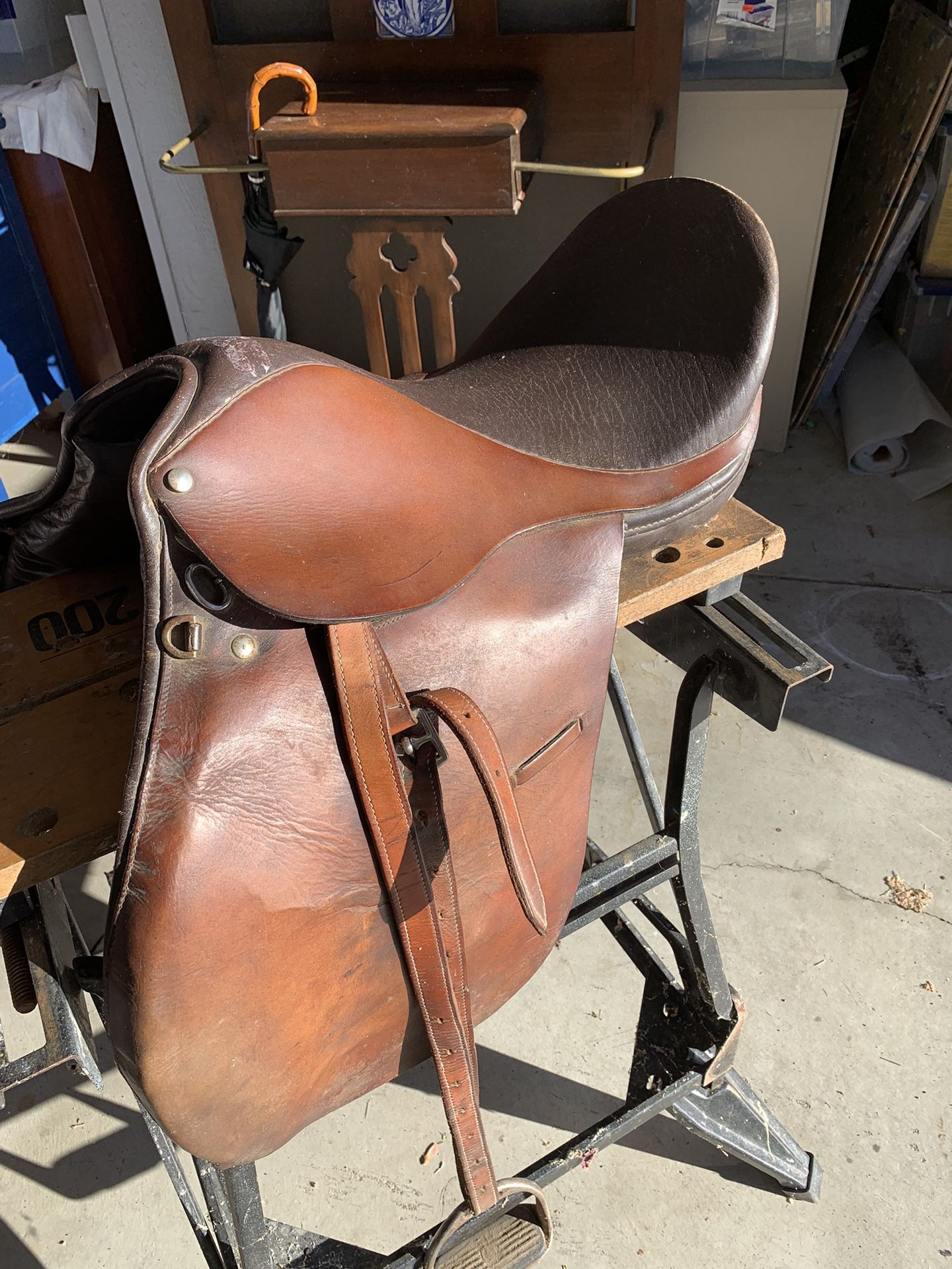 Leather English riding saddle with girth strap and stirrups good condition.