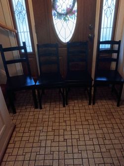 Four black wooden kitchen / dining room chairs