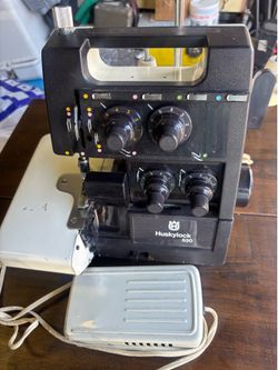 Vintage Husqvarna Huskylock 530 serger sewing machine is a black and white 4-thread overlock machine. It has four adjustable tension dials, a built-in