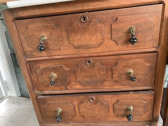 Mid-20th century A French Provincial style three-drawer wooden chest with ornate pulls.