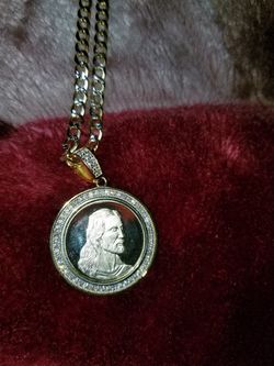 Gold plated silver chain and charm.. chain is 28" and charm has zirconium in the front.. back of the charm is the last supper.