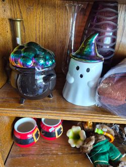Halloween decorations on the witches cauldron, and a ghost with a witch. Hat ceramic four dollars each
