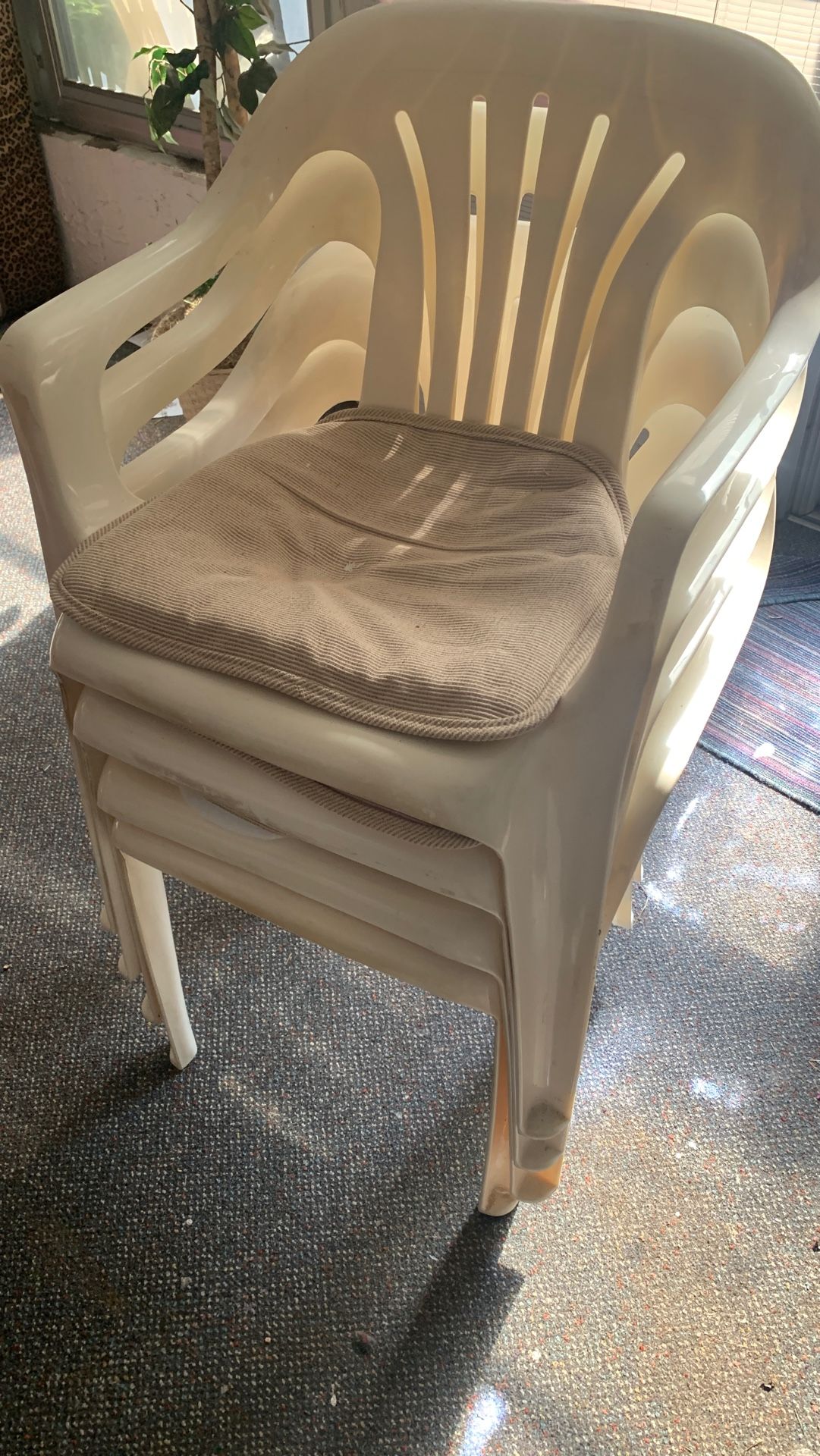 4 plastic chairs with cushions