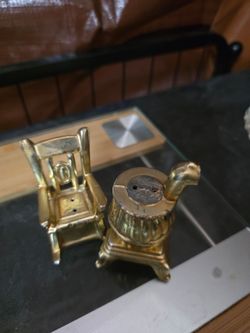Vintage brass colored salt and pepper die cast rocking chair and wood stove