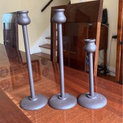 Three metal brown candlestick holders 8 inches to 11 inches tall