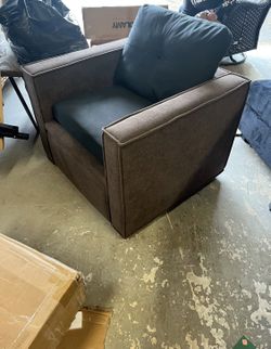 This is a brown fabric accent chair with a black seat cushion. 