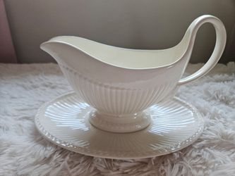 Elegant cream-colored earthenware gravy boat with a matching underplate
