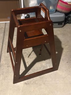 Two Alpine Industries mahogany finish wooden stackable feeding baby high chair featuring a sturdy flared-leg base and a classic commercial restaurant 