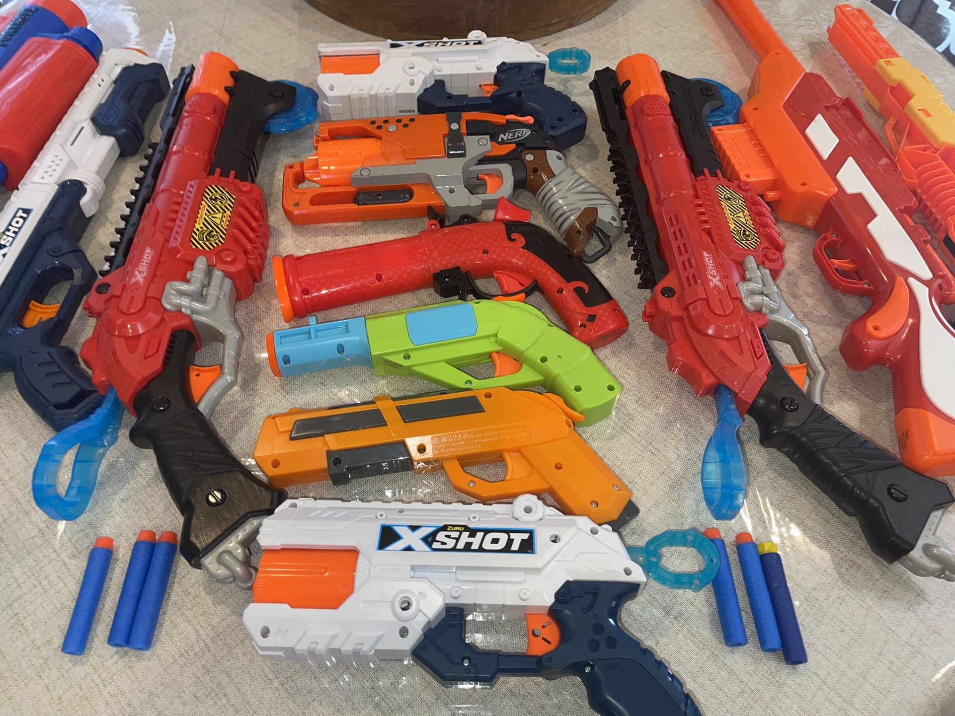12 ASSORTED NERFSTYLE GUNS ALL WORKING NO BULLETS. RIFLES AND HAND GUNS. SELL AS A LOT NOT SEPARATE.
