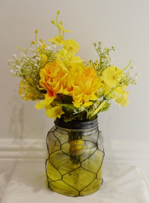 Farmhouse style yellow wire case with flowers and acrylic water