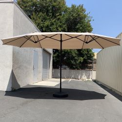 $130 (New) Large 15 ft double sided outdoor umbrella with 65 lbs plastic weight base (beige color) 