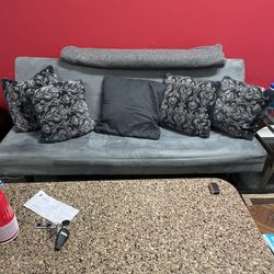 Sofa bed with five pillows and a new blanket