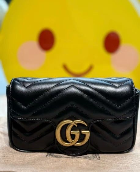 Gucci black Mammon chain crossbody bag on one shoulder
