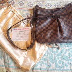 This is an authentic LOUIS VUITTON Damier Ebene Bloomsbury PM.  