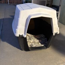 plastic outdoor dog house. It features a barn-style roof designed to protect pets from outdoor elements