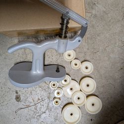 hand-operated press tool with various dies.