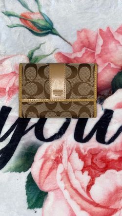 Coach Signature canvas and leather trifold wallet in a brown and tan color scheme