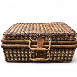 vintage woven wicker picnic basket with a leather handle and metal clasp