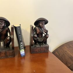 pair of vintage hand-carved wooden bookends featuring seated men smoking pipes, likely originating from the Philippines