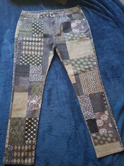Unique patchwork patterned pants with a mix of geometric and floral prints in olive green, tan, and brown tones. These pants are made from a cotton-bl