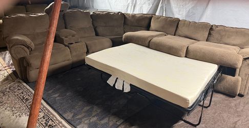 Brown recliner couch has two recliners, two cupholders a storage and two lights. Also a pullout bed great condition clean we sell all the time deliver