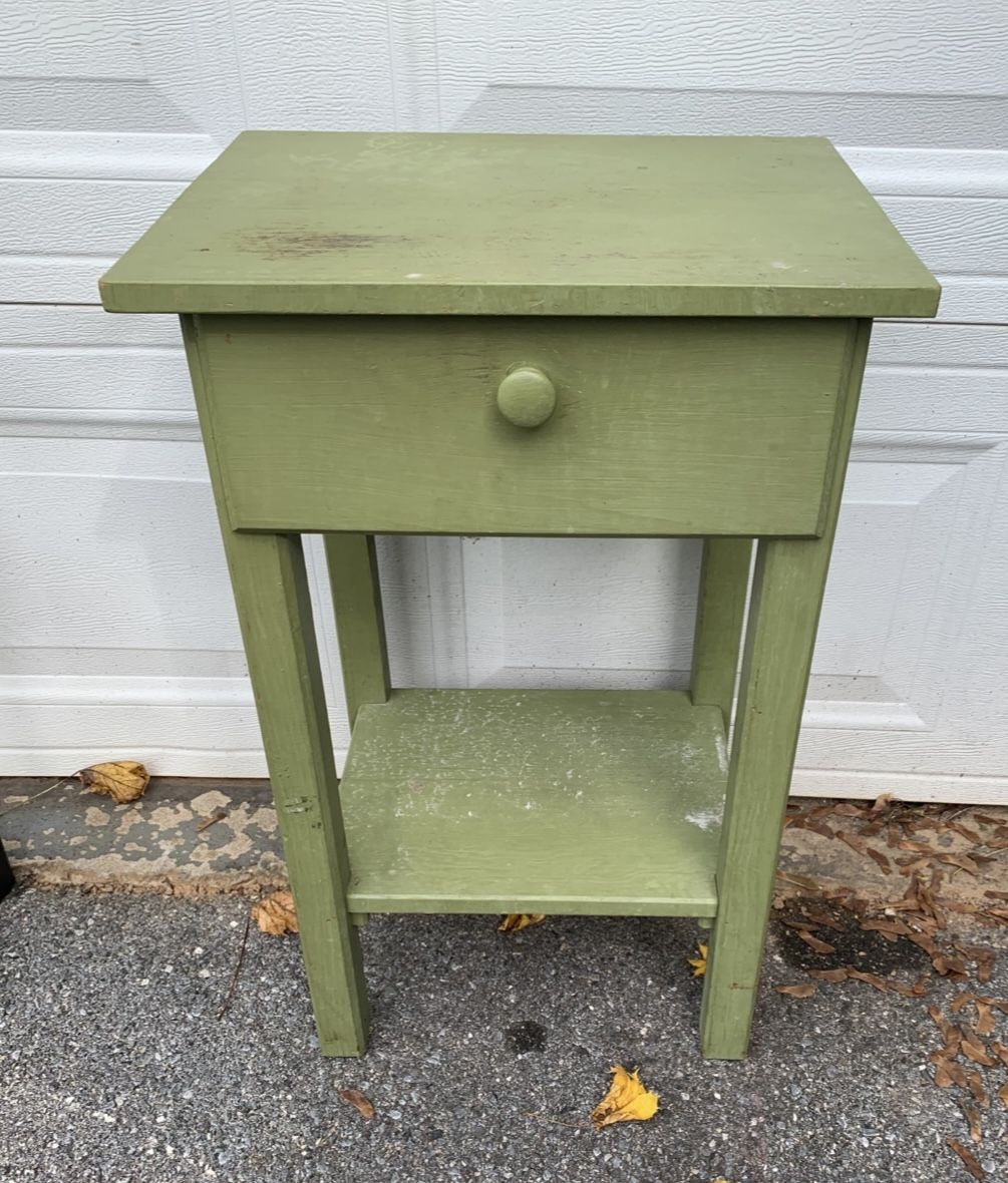 Vintage painted wood side table with one drawer and lower shelf. Measures 17”W x 13”D x 27.5”H. Solid and sturdy with visible paint wear, scuffs, and
