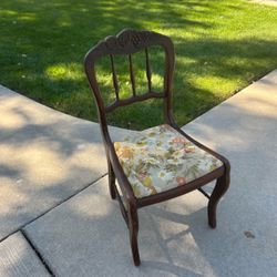 Vintage wooden side chair with hand-carved grape and leaf crest rail and a retro floral fabric seat