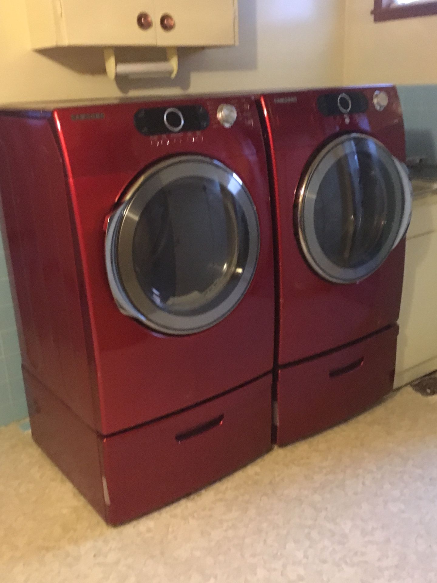 Matching set washer and dryer with pedestals.