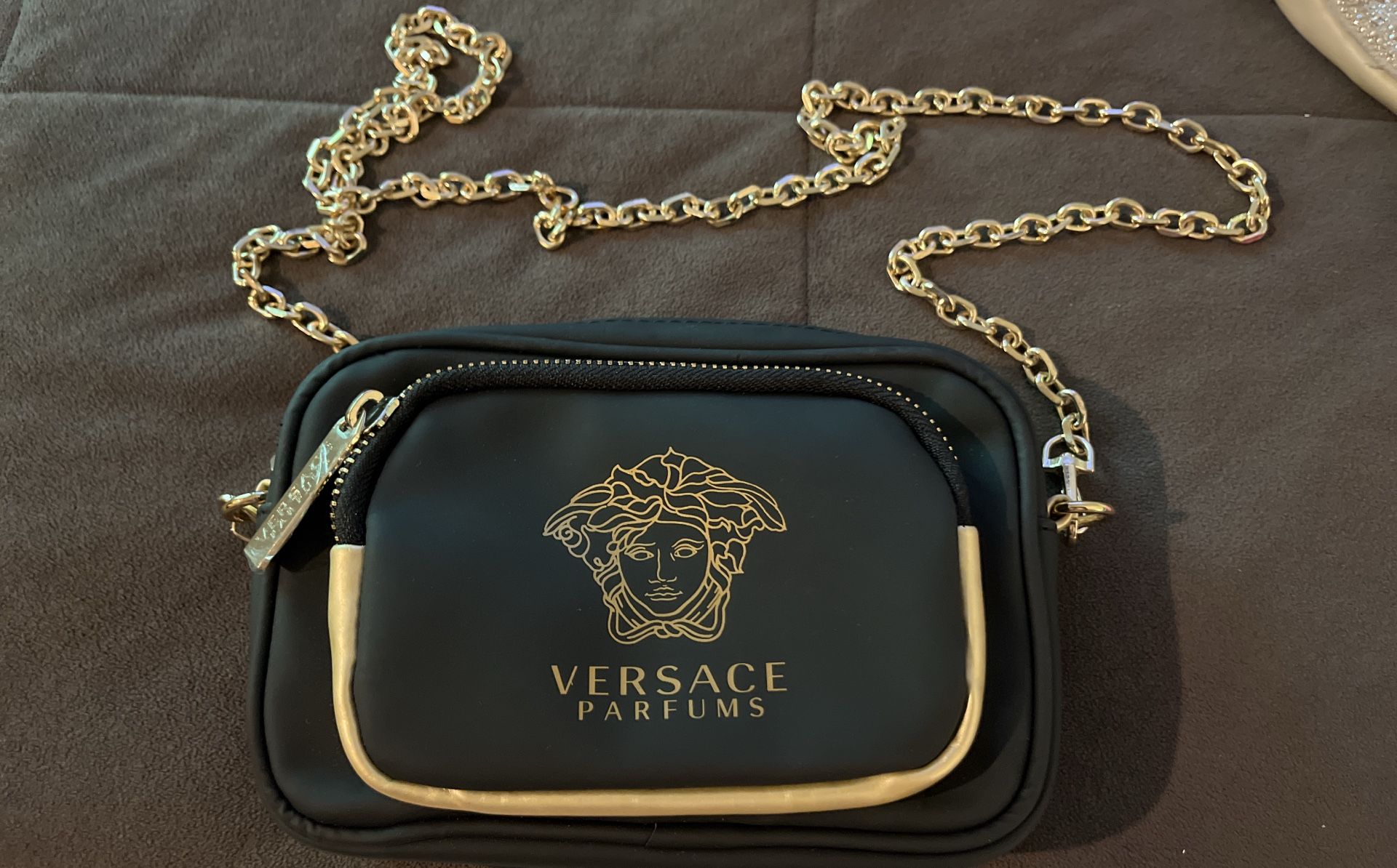 ag with a gold-tone chain strap and the Versace Medusa logo on the front.  Key features include:  Brand: Versace Parfums Design: Crossbody bag with a 