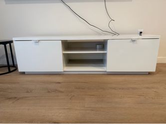 Selling a white TV stand in good condition. Clean, sturdy, and works great. It has two side cabinets and open shelves for storage.
