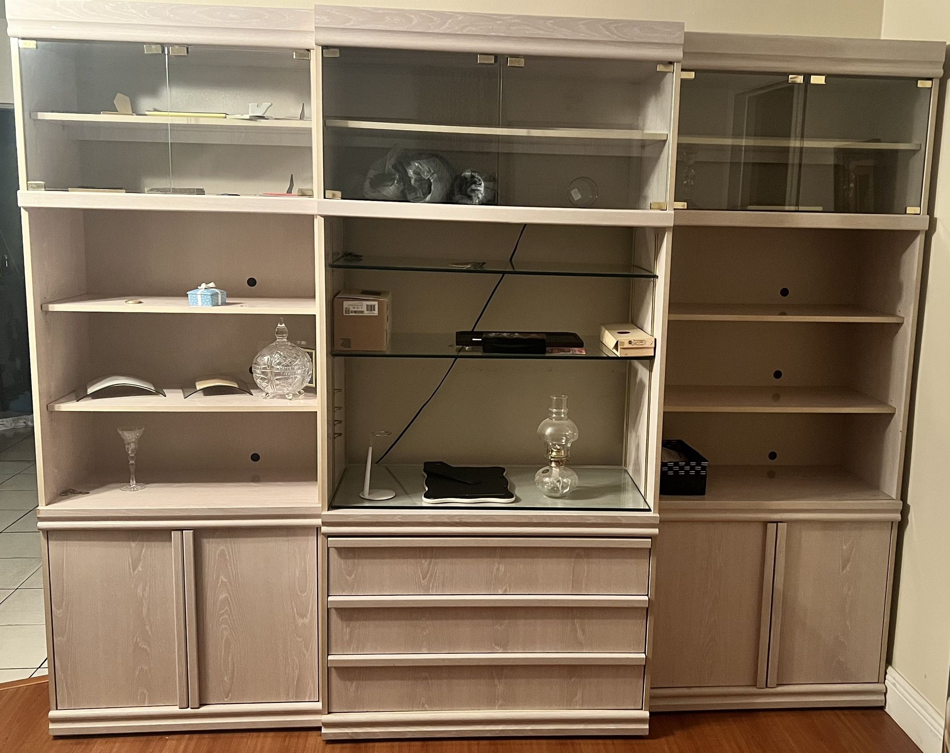 Light-colored wooden display cabinet with glass doors.