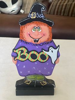 Hand-painted wooden folk art Halloween witch holding a Boo sign. 10.5”