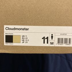On Cloudmonster running shoes, black with an acacia or light-colored sole.   11