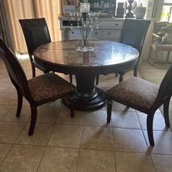 Solid wood w/ marble top kitchen table, 4 chairs with leather backs , carved designs in wood , beautiful table