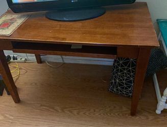 This Winsome Wood Studio computer desk in honey features a pull-out keyboard tray and tapered
