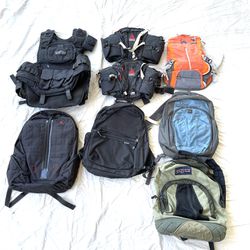 A collection of backpacks, hiking bags, and tactical vest